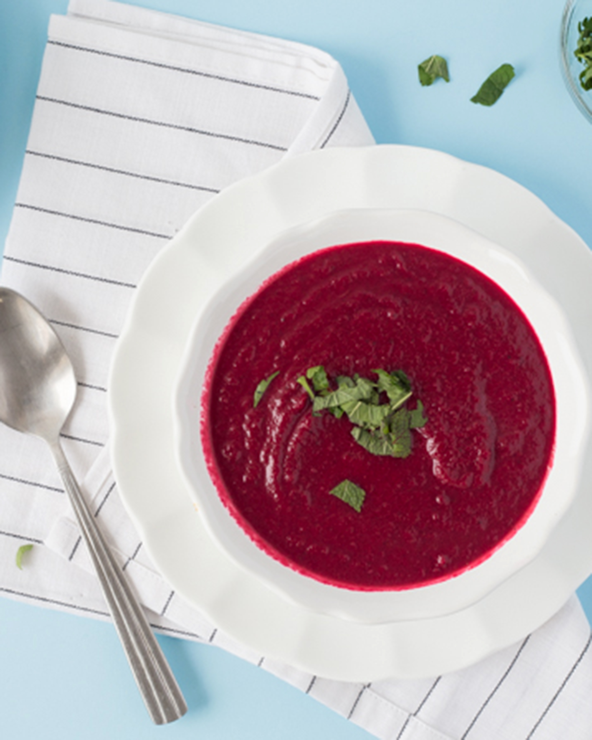 A photo of delicious spiced apple-beet soup with spoon