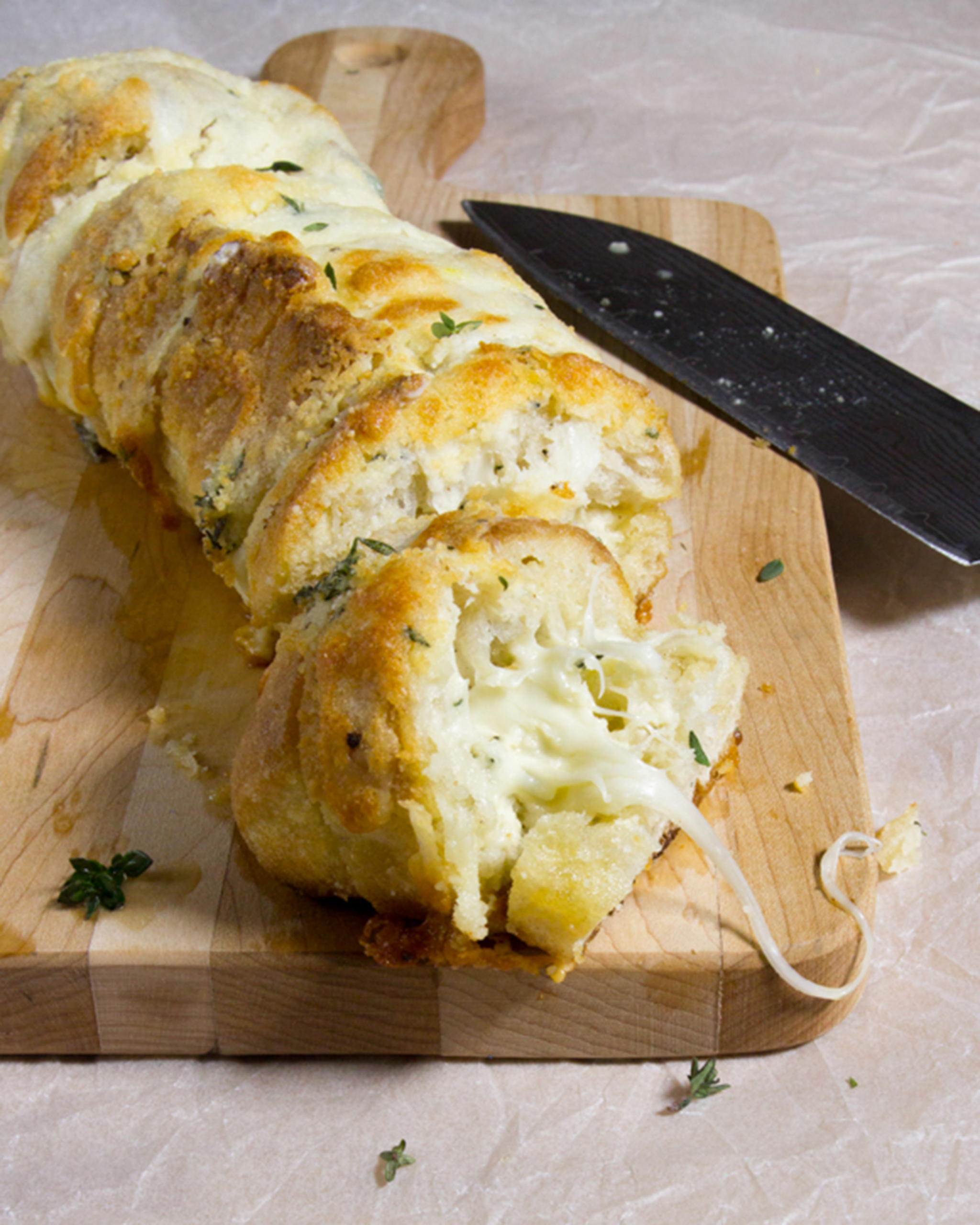 A photo of sliced garlic cheese bread on a cutting board